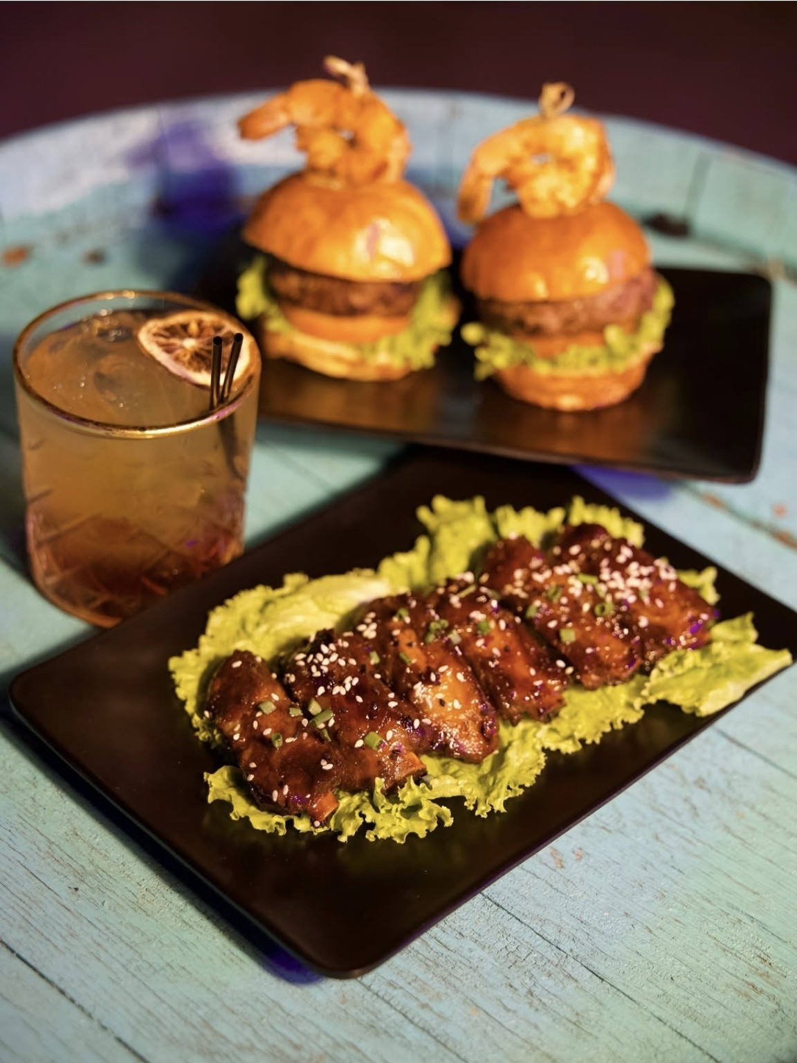 Sliders, glazed chicken wings and a cocktail served at Santorini Curaçao